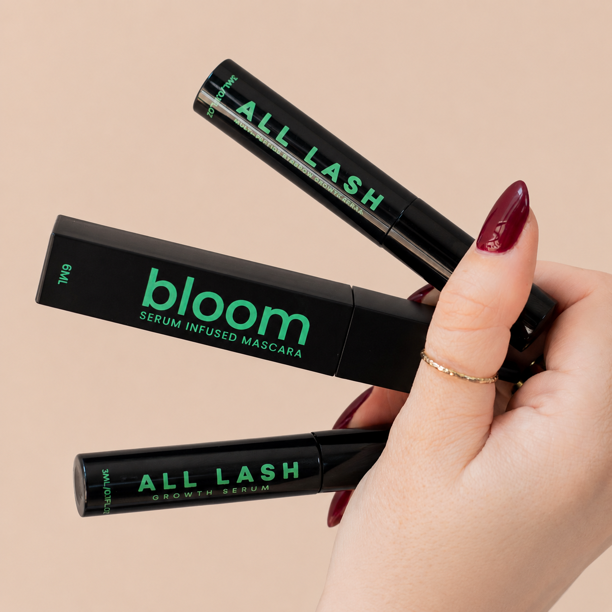 "ALL-LASH lash and brow growth serum with Bloom Serum Infused Mascara held in hand on a beige background
