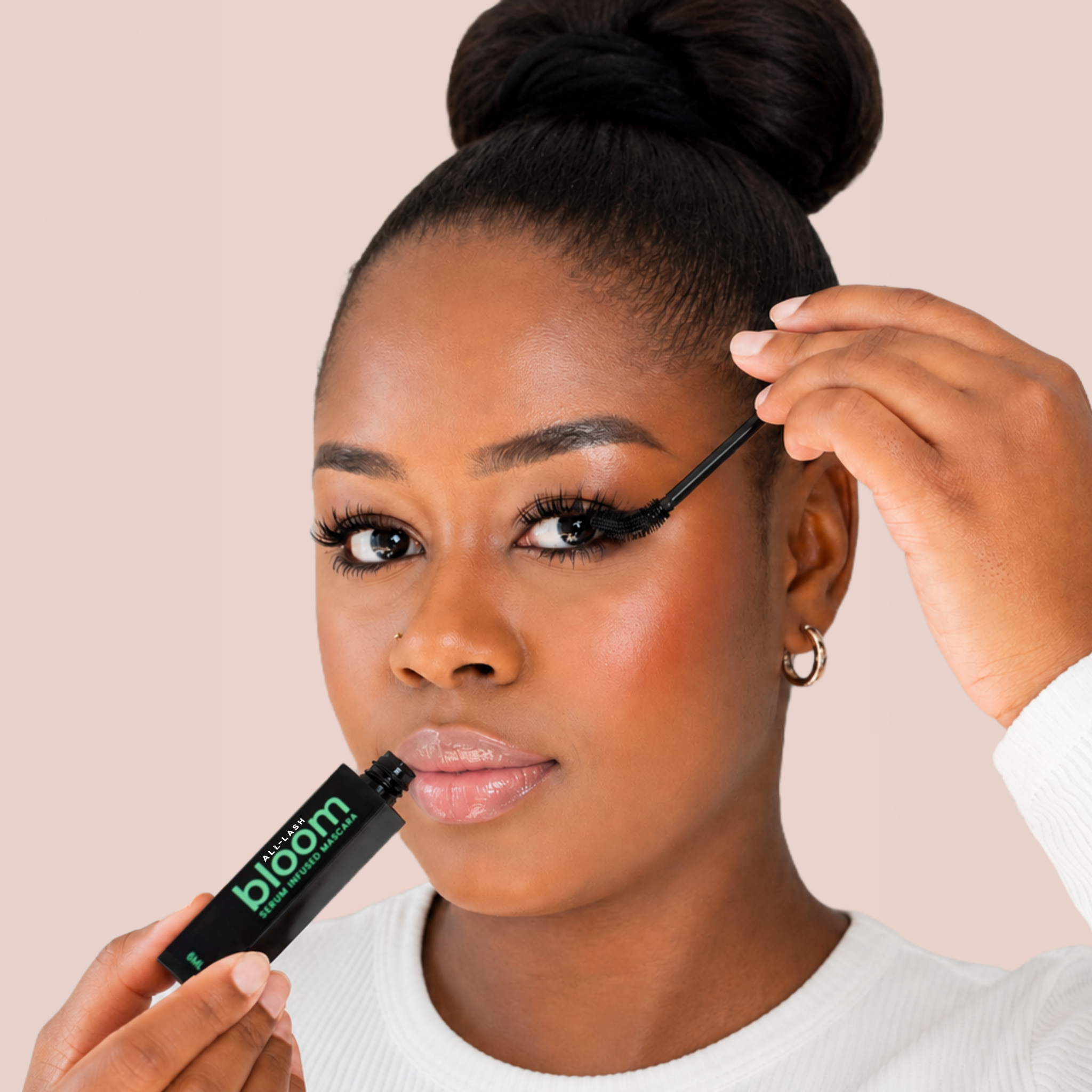 Model applying ALL-LASH Bloom Growth Mascara for longer, fuller lashes with a serum-infused tubing mascara formula